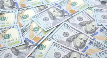 A pile of one hundred US banknotes with president portraits.