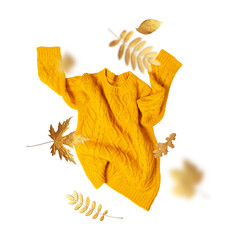 Cut out yellow orange flying women's knitted sweater, golden autumn leaves isolated on white background. With clipping path. Clothing concept, trendy fall winter cozy sweater pullover jersey