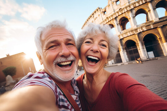 A happy elderly couple of tourists take a selfie in front of the Colosseum. Travel retirement concept. AI generated.