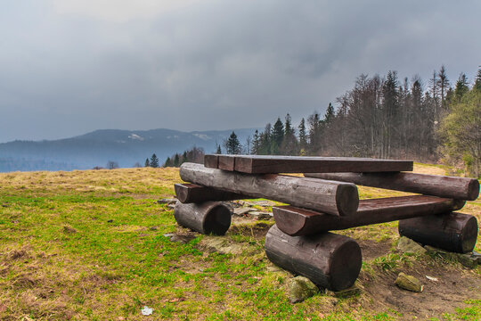 Resting point on the Śwink&oacute;wka clearing by the blue tourist trail to Gorc on a spring cloudy day (Gorce, Poland)