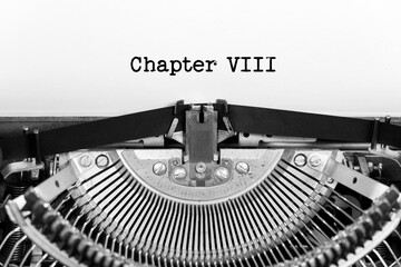 Chapter Eight phrase closeup being typing and centered on a sheet of paper on old vintage typewriter mechanical