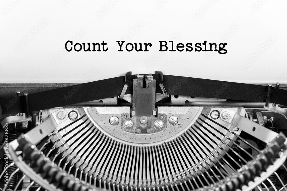 Poster count your blessing phrase closeup being typing and centered on a sheet of paper on old vintage type