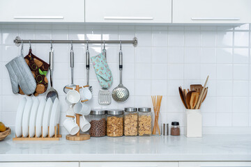 Assortment of grains, cereals and pasta in glass jars and white glass drinking set equipment on the kitchen on white table. Flat lay, Concept of food preparation, kitchen on background.