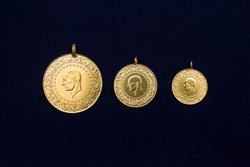 full, half and quarter Turkish gold coins side by side on a dark navy blue background