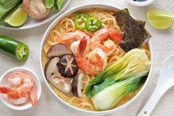 Asian spicy soup with noodles, shiitake mushrooms, shrimp and bok choy. Top view.