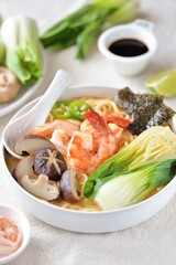 Asian spicy soup with noodles, shiitake mushrooms, shrimp and bok choy. 