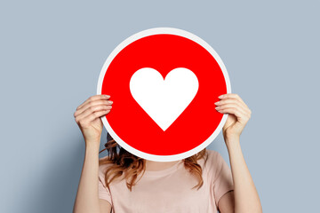 girl holding a like poster isolated over grey background
