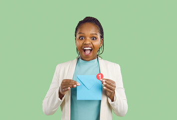 African American Woman holding mail sign. Happy excited woman on light green background holding...