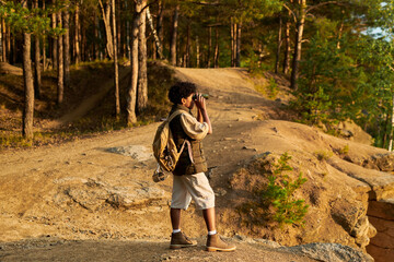 African American boy using binoculars during hiking