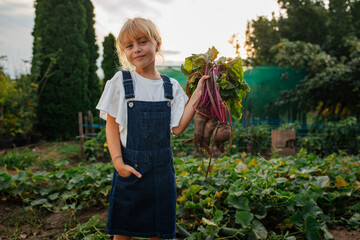 Little girl posing while holding beet