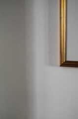 Golden vintage frame detail hanged on the wall at home between shade and light. - 633449463