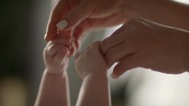 Mother and newborn baby in maternity home. Hand in hand. Parenthood. 
