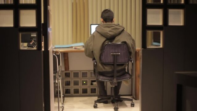 Corporate office shot of a man working on a desktop - turning back to see the empty office space - HD footage - 24 fps - ProRes

