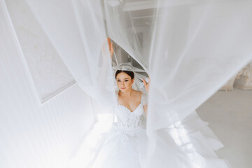 Preparation for the wedding. Beautiful young bride in white luxurious wedding dress, tiara on head,...