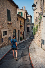 Fototapeta na wymiar Frau spaziert durch eine historische Altstadt in Italien