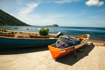 Close-up of traditional dugout fishing boats beached along the ocean front promenade in the small, fishing village of Soufriere on the Island of Dominica; Soufriere, Dominica, Caribbean