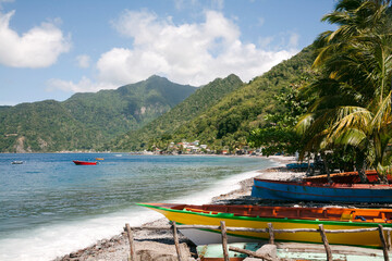 Coastal, scenic view of traditional dugout fishing boats beached along the shore of the small village of Scotts Head in Soufriere Bay on the Island of Dominica; Soufriere, Dominica, Caribbean