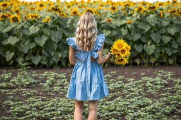 Young beautiful woman with a bouquet of sunflowers