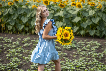 Young beautiful woman with a bouquet of sunflowers