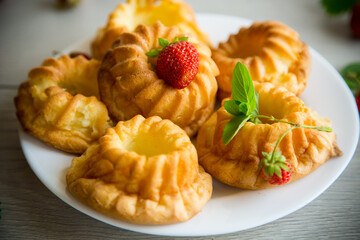 Cooked sweet curd cupcakes with fresh strawberries and mint