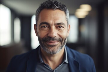 Obraz premium Middle aged businessman of latin ethnicity smiling in a modern office
