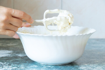 Beat eggs with sugar on a mixer on a table in the kitchen, preparing dough for a pie