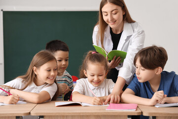 Fototapeta na wymiar Little pupils having lesson with teacher in classroom