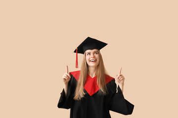 Female graduate student pointing at something on beige background