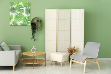 Interior of living room with armchair, grey sofa and painting