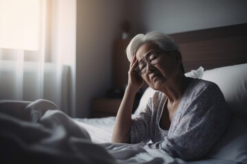 Senior woman having a headache and feeling sick in the bedroom at home