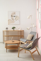 Interior of living room with cozy grey armchairs, coffee table, shelving unit and beautiful painting
