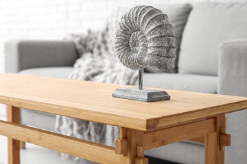 Light wooden coffee table with figurine in living room