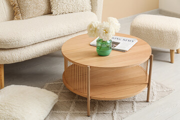 Wooden coffee table with vase of flowers in living room