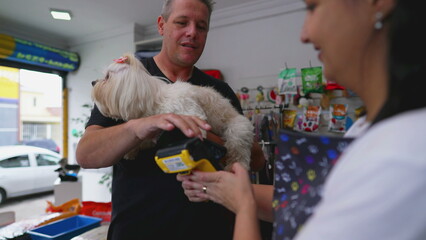 Conctactless payment with Phone. Customer Paying for Pet Shop Grooming Service for his Dog
