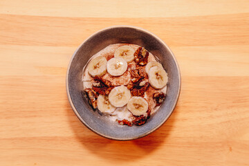 top view of a bowl with yogurt, bananas and nuts.