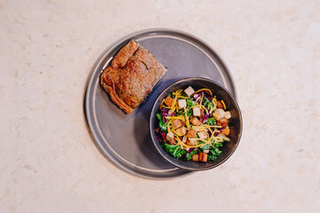 Presentation of a Caesar salad dish accompanied by a vegetable tart.