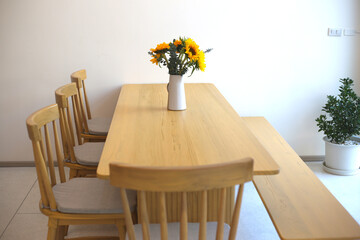 sunflower flowers in vase on wooden table in cafe with sunlight 