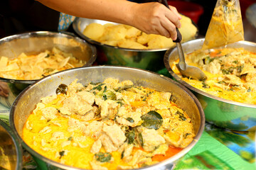 selling thai Green curry with meatballs, eggplant , coconut shoots and bamboo shoots in the market