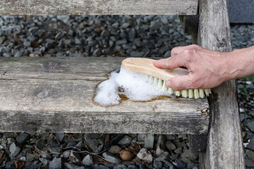 A man is holding a floor scrubbing brush.