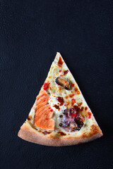 Piece of delicious pizza with seafood on dark background. Flat lay. Top view.Copy space.