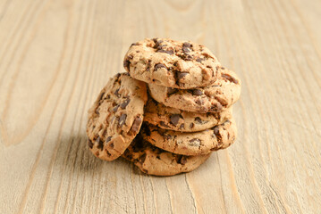 Tasty cookies with chocolate chips on wooden background