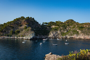 Fototapeta na wymiar Aerial view of Taormina, Sicily in Italy. Tree covered hills and and water of bay with boats