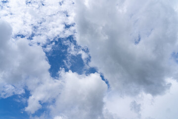 white fluffy clouds standing out against a black background and a blue sky