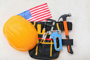 Belt with different tools, hardhat and USA flag on white background. Labor Day celebration