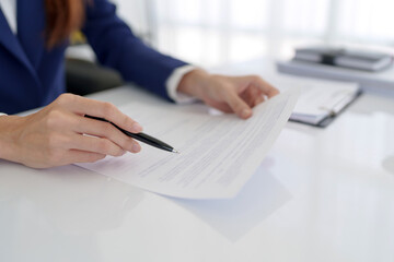 Lawyer preparing to sign a contract reading documents at office room.