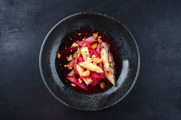 Deutscher Rhabarber Spargel Salat mit Cashew Nüssen in Himbeersauce serviert als Draufsicht in einer Nordic Design Schale mit Textfreiraum