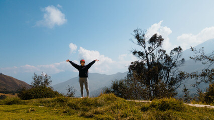 Mujer excursionista  viajera, aventurera con mochila sinti&eacute;ndose victoriosa frente a la monta&ntilde;a, al aire libre para la educaci&oacute;n de la naturaleza en vacaciones. Concepto de viaje,estilo de vida