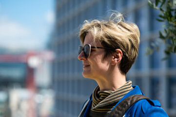 Portrait of a 37 yo white woman with a blue jacket and sunglasses, Belgium