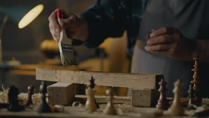 Sawing, Business owners Staining wood with protective paint In a woodworking shop In slow motion Junior specialist Working with solid wood at a work table In a woodworking shop, wood shavings