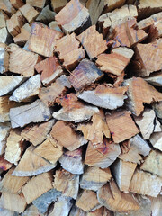 Pile of pieces of firewood of varying sizes and shapes cut and arranged.